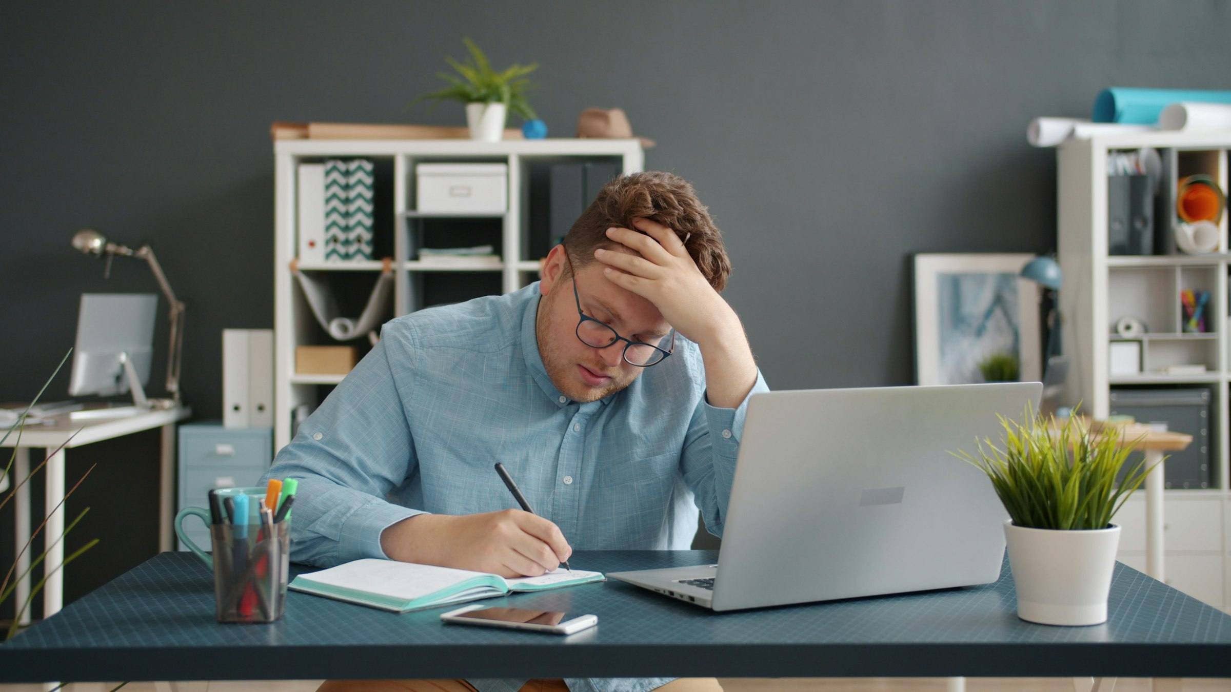 A business owner at his desk, head in hand, buried in work